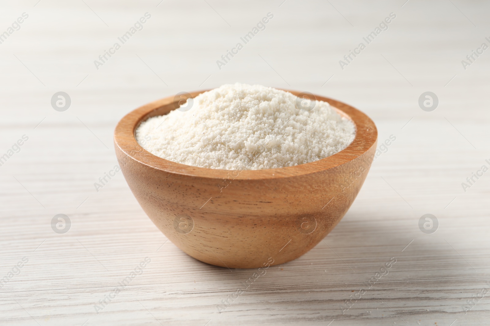 Photo of Fresh coconut flour in bowl on white wooden table