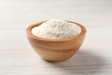 Photo of Fresh coconut flour in bowl on white wooden table