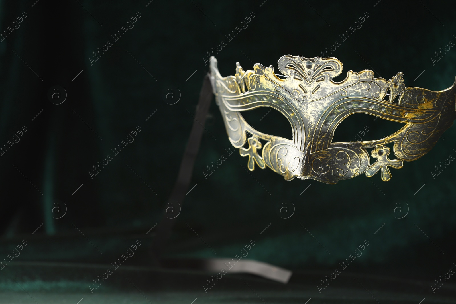 Photo of Theater arts. Venetian carnival mask against green fabric, space for text