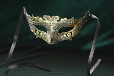 Photo of Theater arts. Venetian carnival mask against green fabric