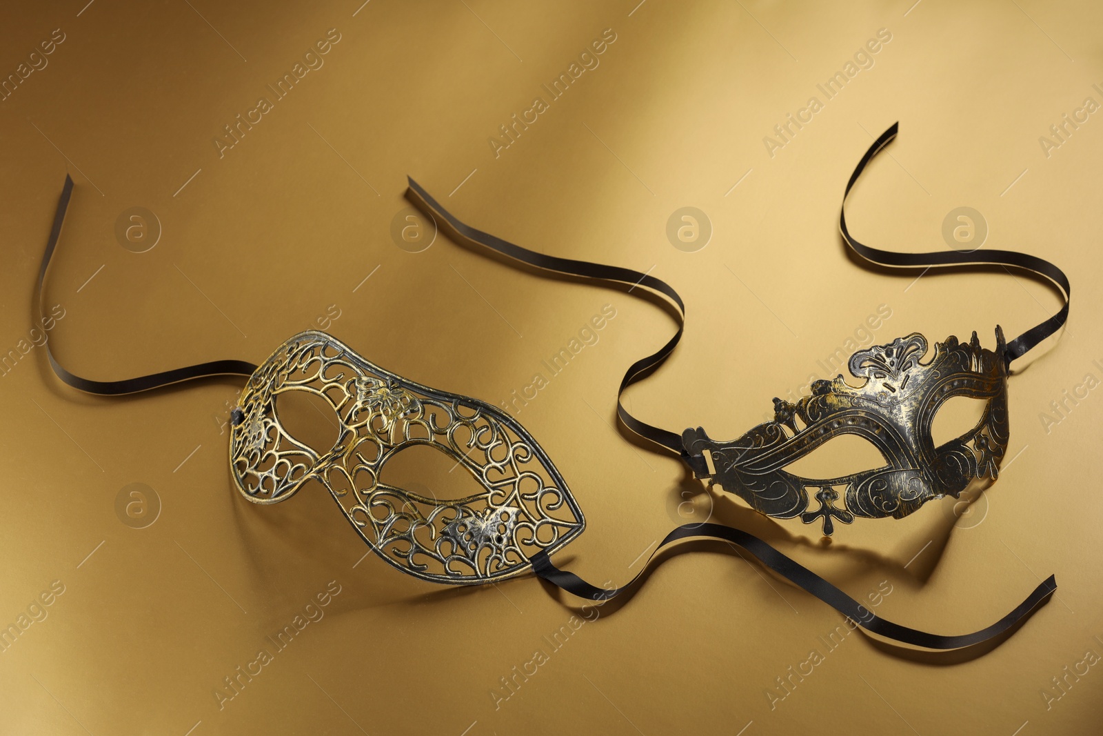 Photo of Elegant face masks on beige background. Theatrical performance