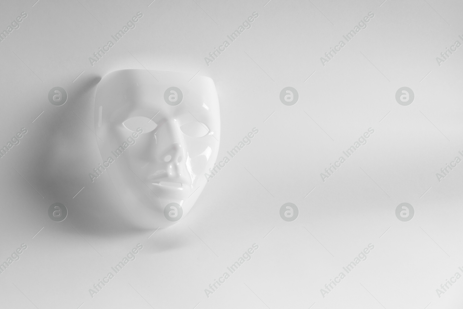 Photo of Plastic face mask on white background, space for text. Theatrical performance