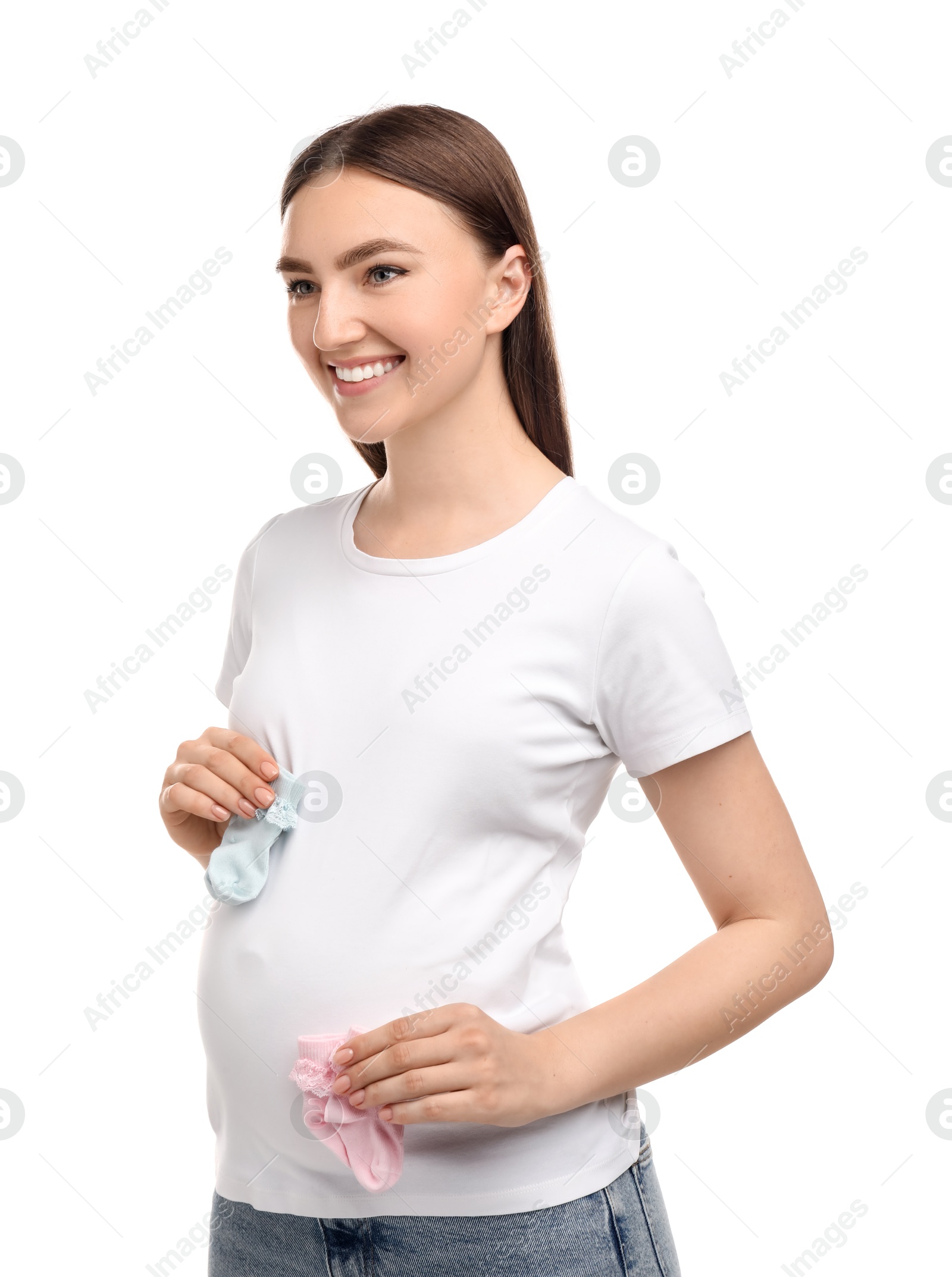 Photo of Expecting twins. Pregnant woman holding two pairs of socks on white background