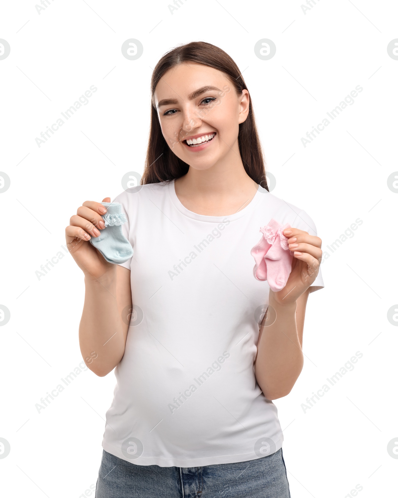 Photo of Expecting twins. Pregnant woman holding two pairs of socks on white background