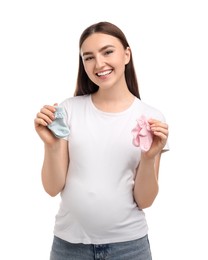Photo of Expecting twins. Pregnant woman holding two pairs of socks on white background