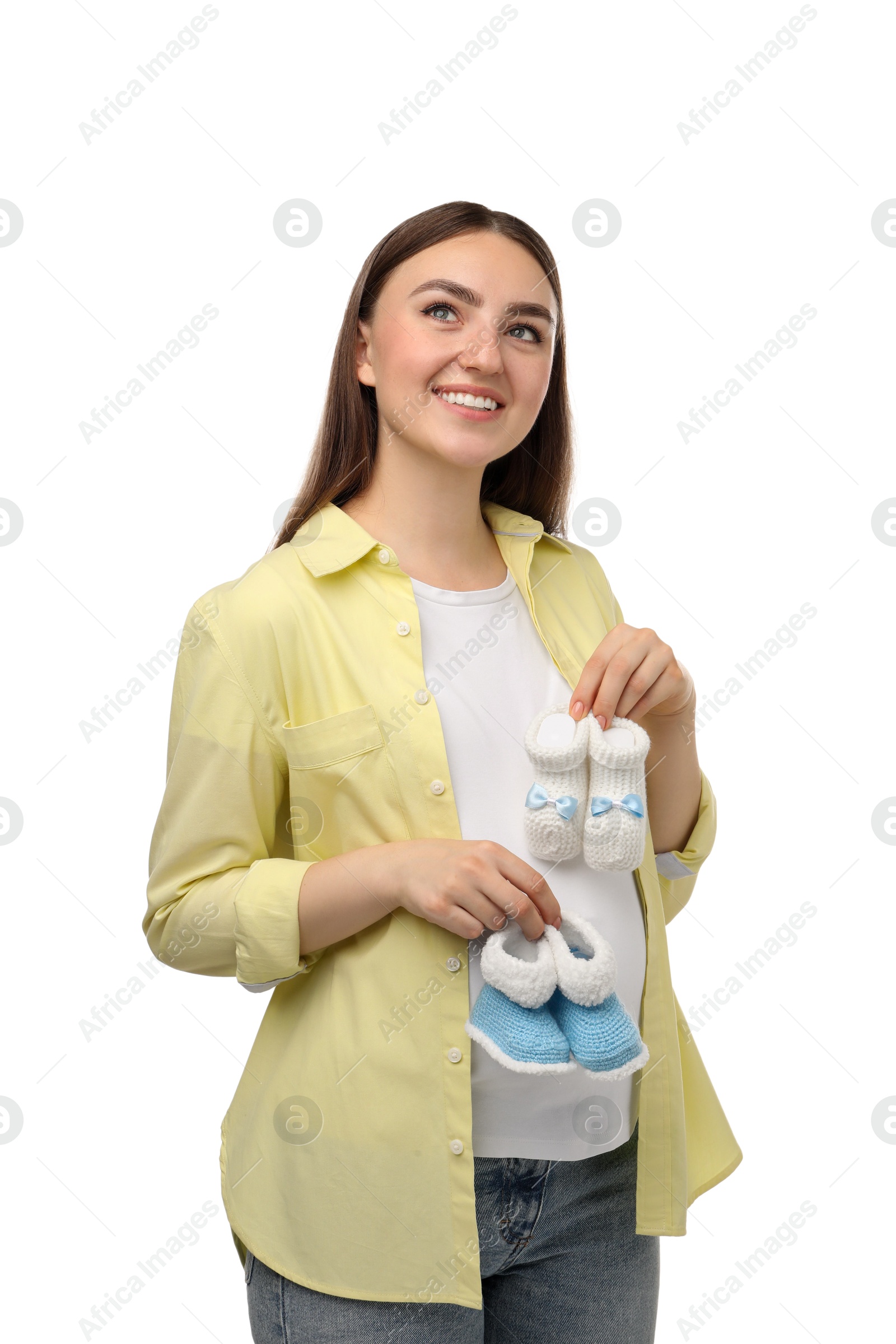 Photo of Expecting twins. Pregnant woman holding two pairs of baby shoes on white background