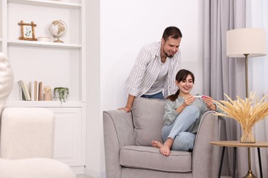 Photo of Happy young couple with pregnancy test at home, space for text