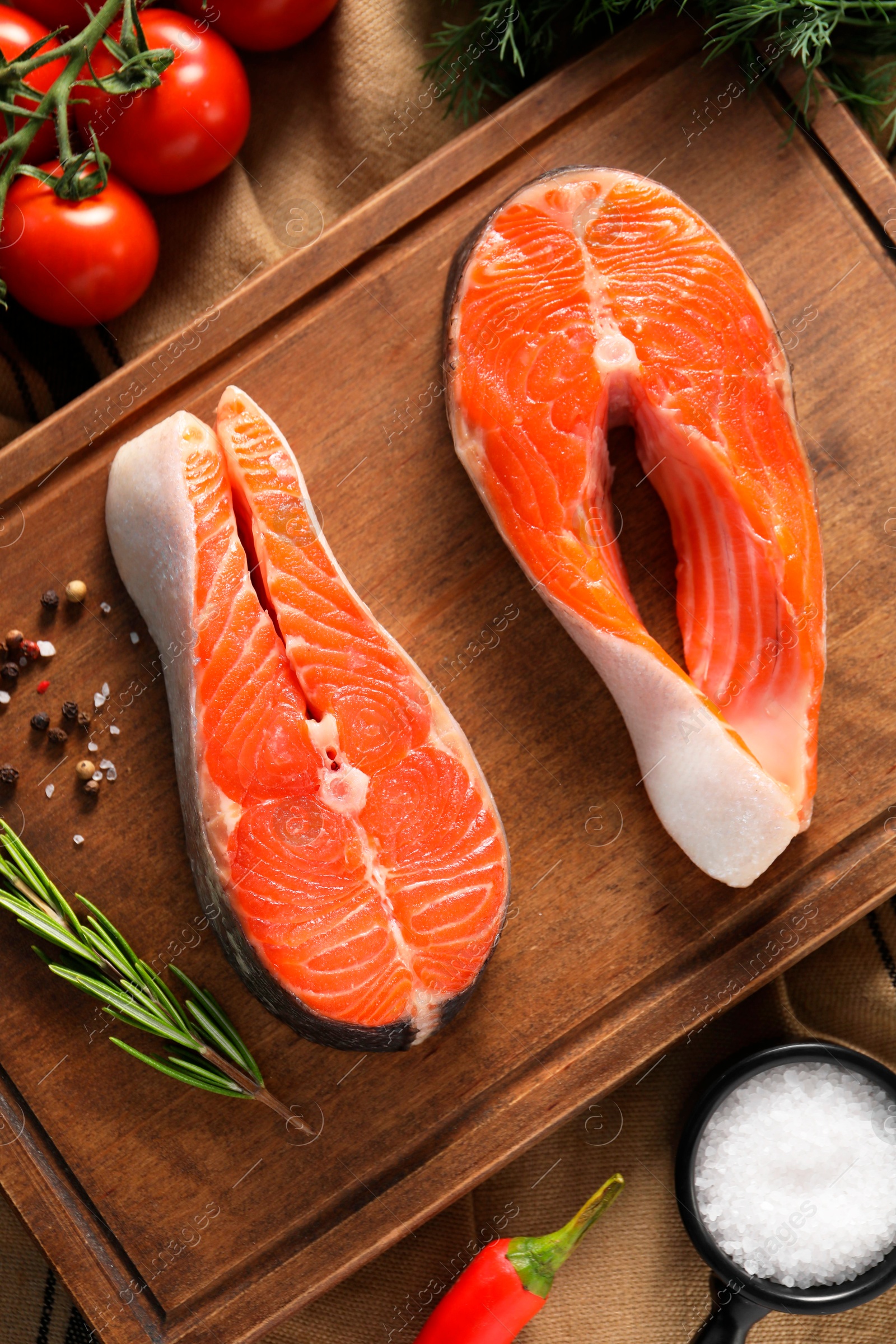 Photo of Fresh salmon steaks, spices and products on table, flat lay