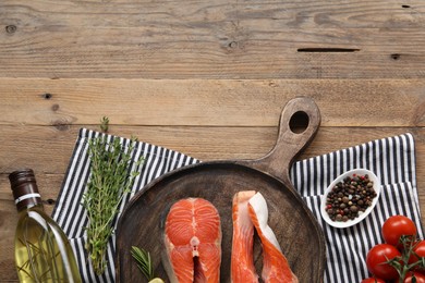 Photo of Fresh salmon steaks, peppercorns and products on wooden table, flat lay. Space for text