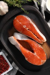 Photo of Fresh salmon steaks, garlic, thyme and peppercorns on table, flat lay