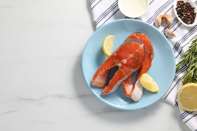 Photo of Plate with fresh salmon steaks, lemon and thyme on white marble table, flat lay. Space for text