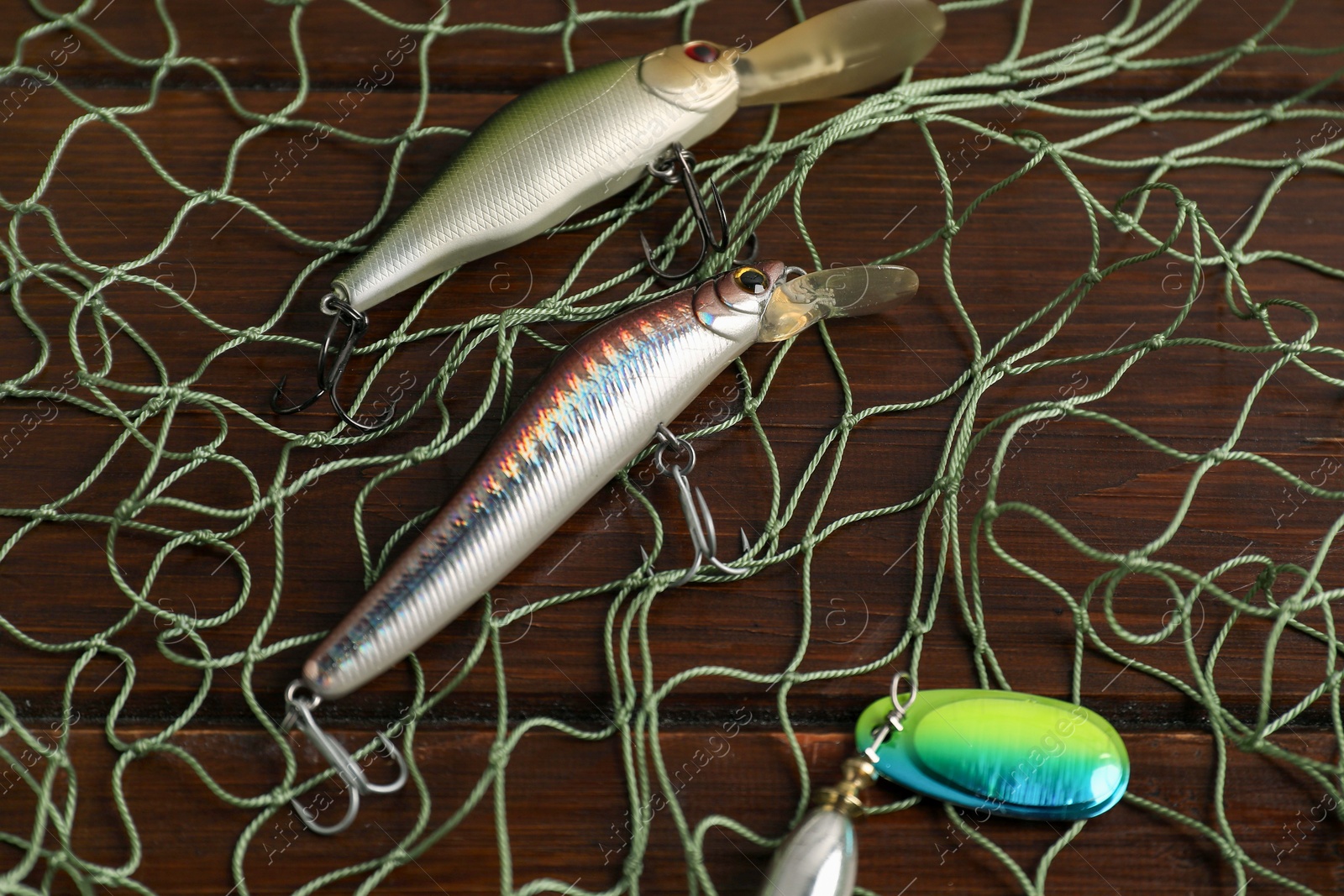 Photo of Fishing net and different lures on wooden table