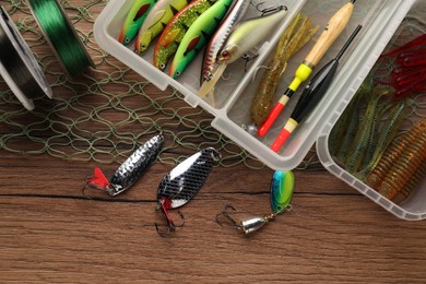 Fishing baits, floats, lines and net on wooden table, top view