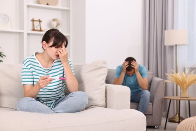 Worried young couple with pregnancy test at home