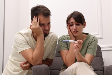 Worried young couple with pregnancy test at home