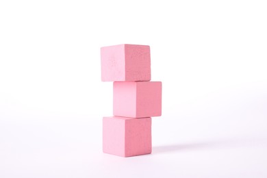 Stack of pink wooden cubes on white background