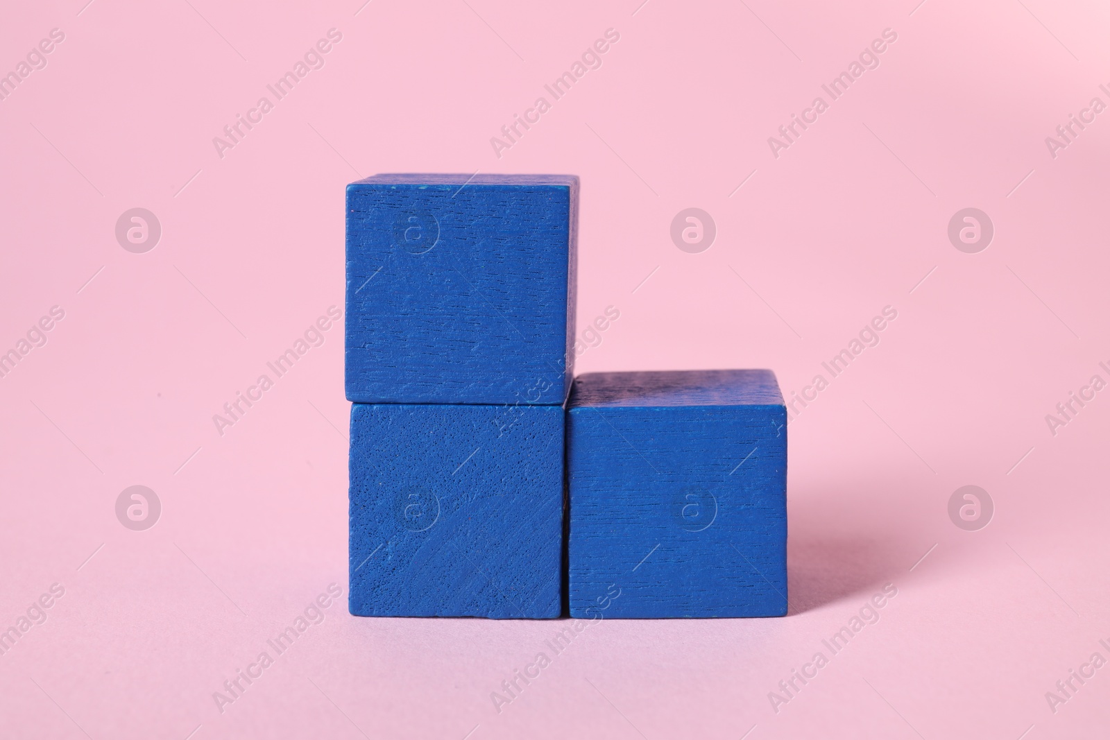 Photo of Many blank blue cubes on pink background, closeup