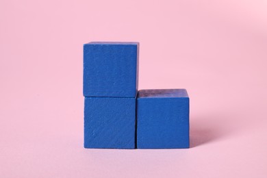 Photo of Many blank blue cubes on pink background, closeup