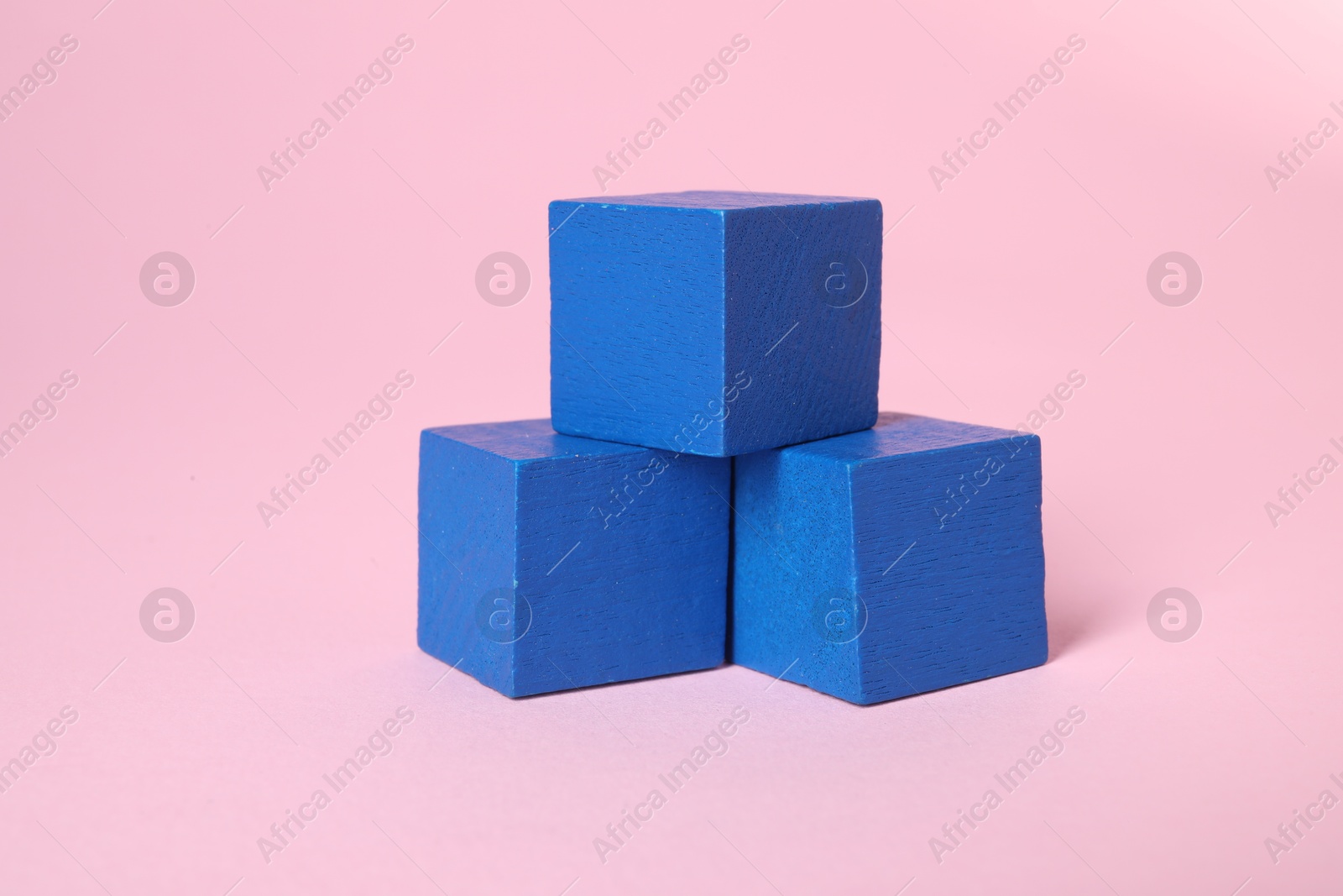 Photo of Many blank blue cubes on pink background