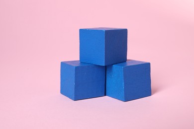 Photo of Many blank blue cubes on pink background