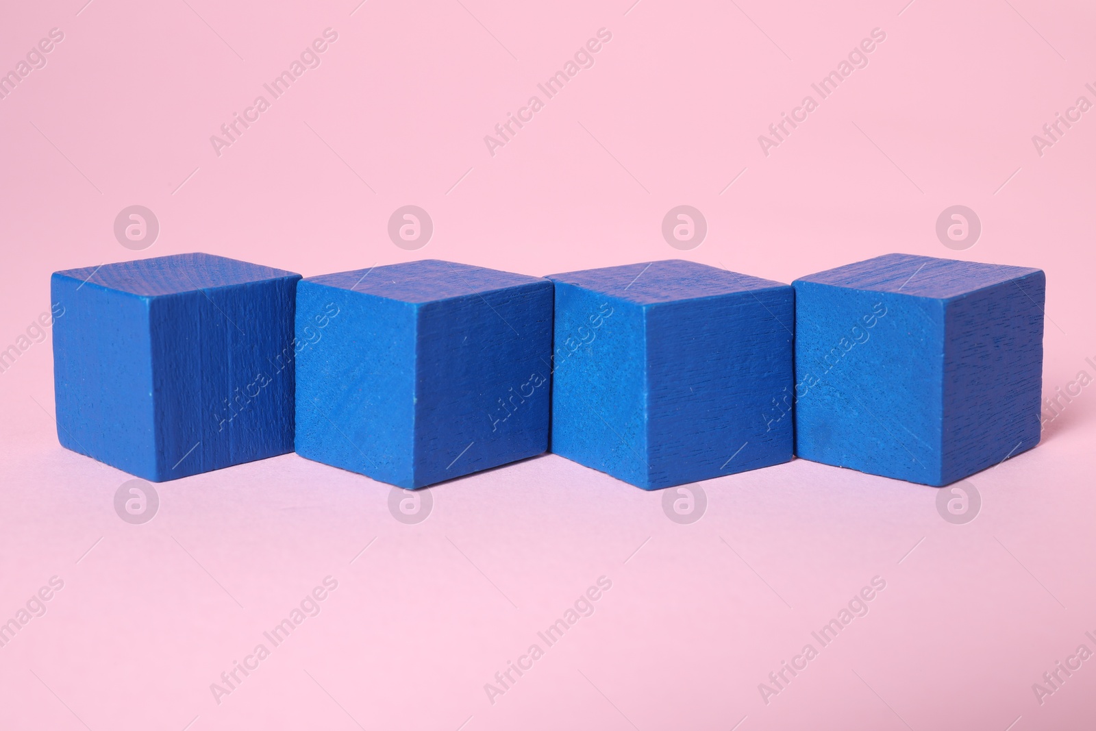 Photo of Many blank blue cubes on pink background