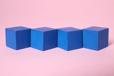 Photo of Many blank blue cubes on pink background