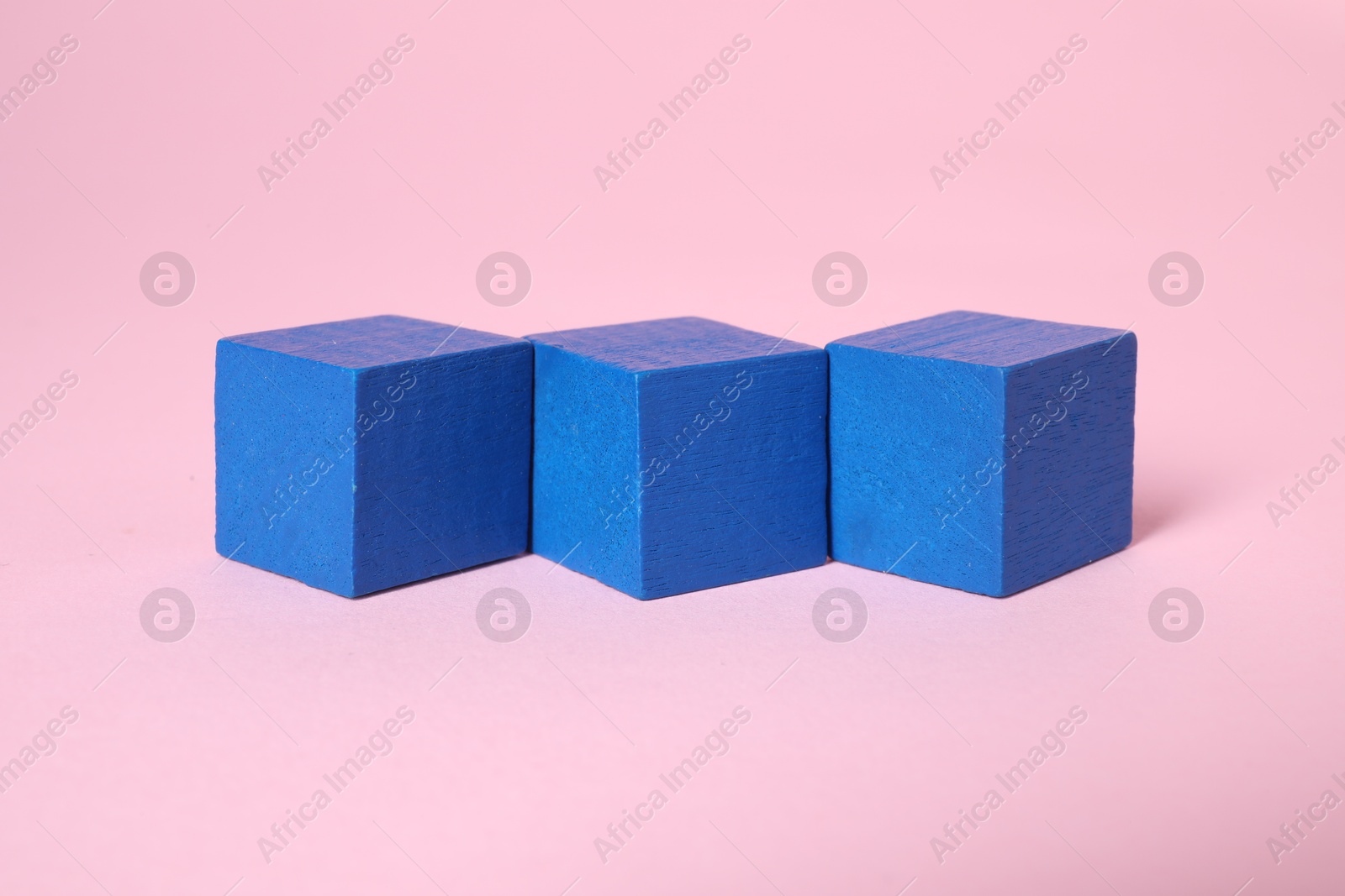 Photo of Many blank blue cubes on pink background