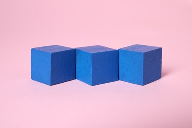 Photo of Many blank blue cubes on pink background