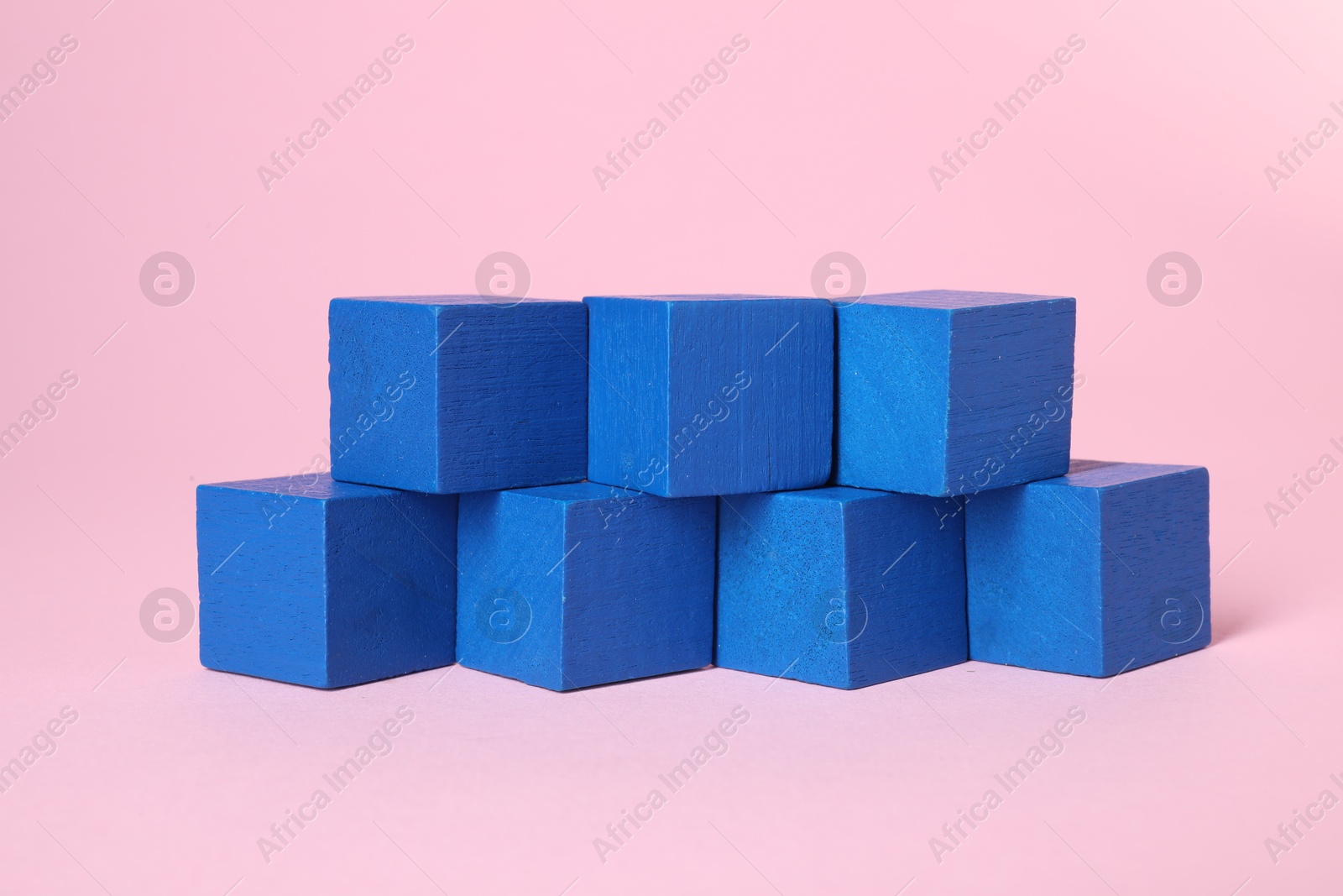 Photo of Many blank blue cubes on pink background