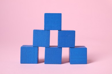 Photo of Many blank blue cubes on pink background