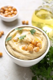 Delicious hummus with olive oil and chickpeas on light table