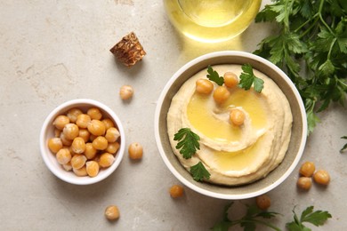 Photo of Delicious hummus with olive oil, chickpeas and parsley on light textured table, flat lay