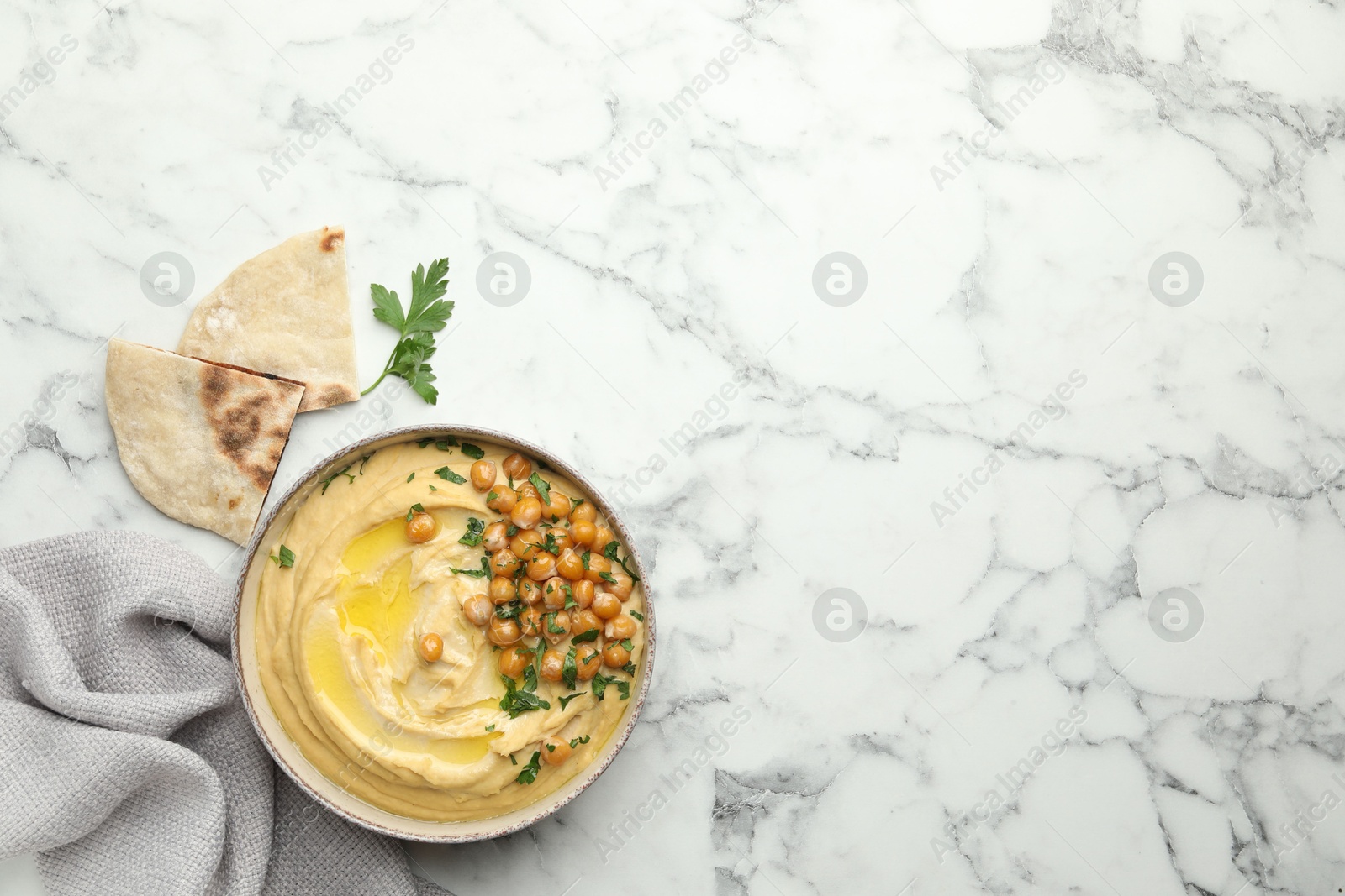 Photo of Delicious hummus with olive oil, chickpeas and pita on white marble table, flat lay. Space for text