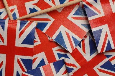 Small paper flags of United Kingdom as background, top view