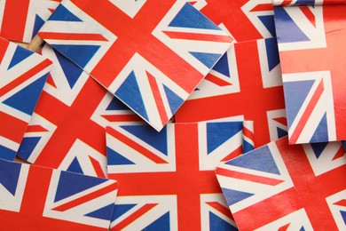 Small paper flags of United Kingdom as background, top view