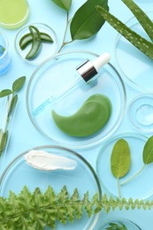 Photo of Petri dishes with different fresh leaves and cosmetic products on light blue background, flat lay