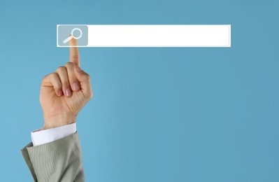 Image of Man using search bar on virtual screen against light blue background, closeup