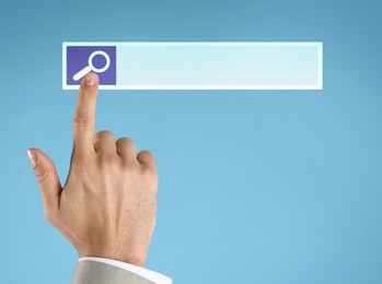 Image of Woman using search bar on virtual screen against light blue background, closeup