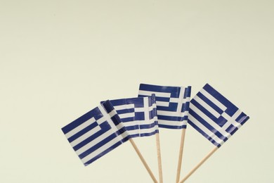 Photo of Small paper flags of Greece on light background