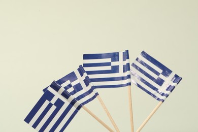 Small paper flags of Greece on light background