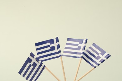 Photo of Small paper flags of Greece on light background