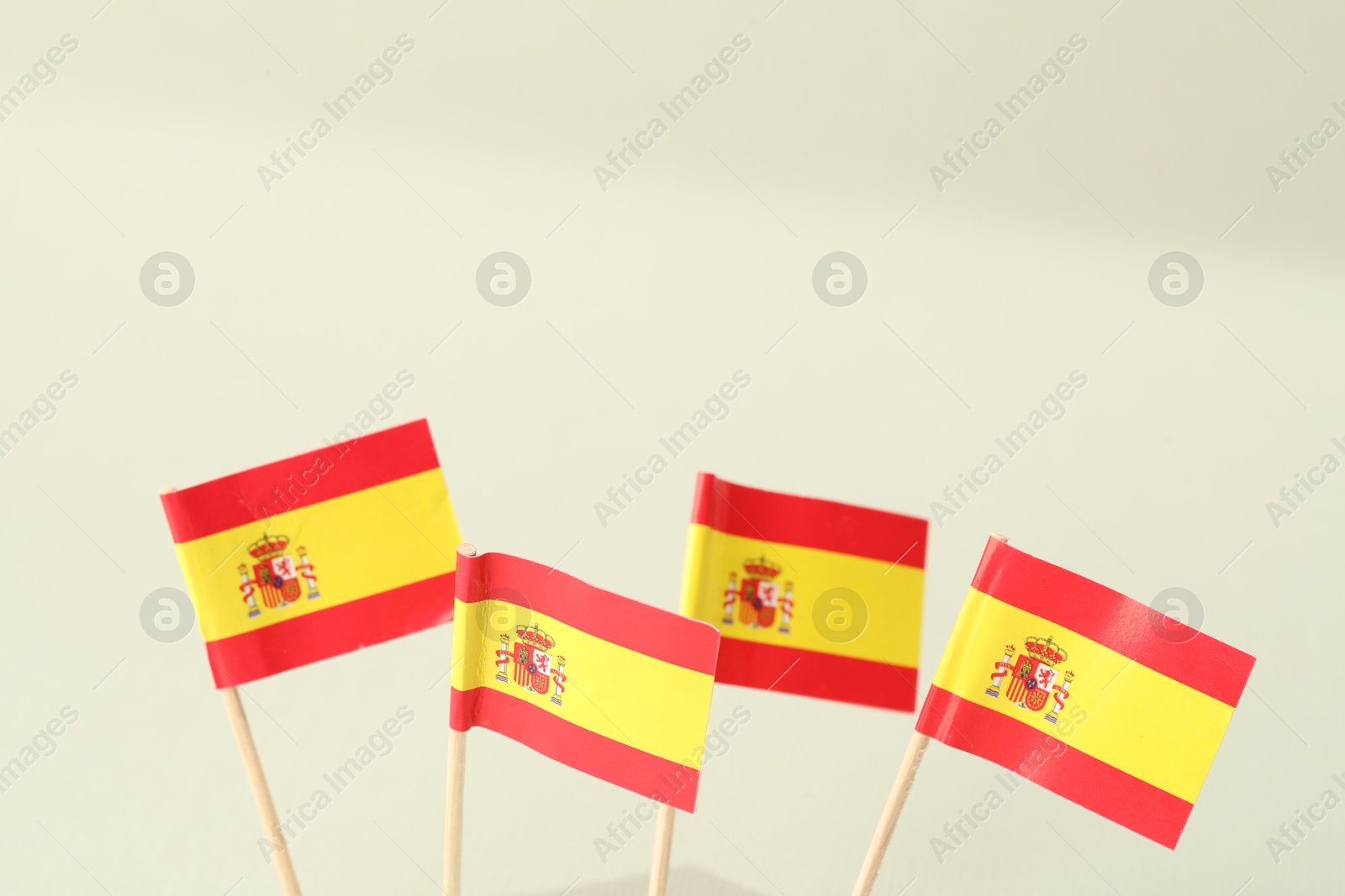 Photo of Small paper flags of Spain on light background