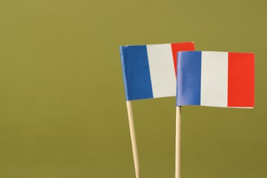 Photo of Small paper flags of France on olive background, space for text