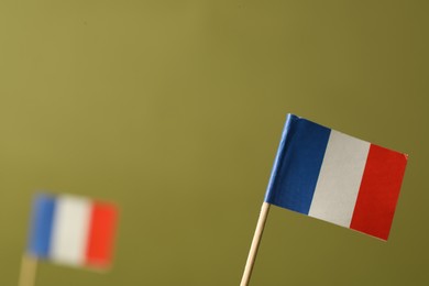 Photo of Small paper flags of France on olive background, space for text