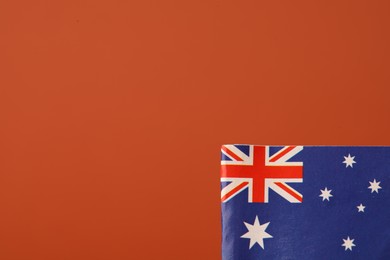 Small paper flag of Australia on orange background, space for text