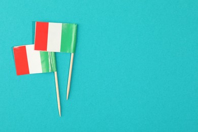 Photo of Small paper flags of Italy on light blue background, top view. Space for text