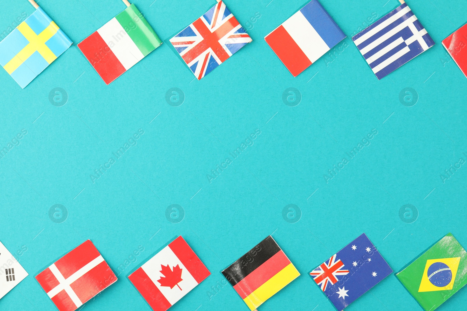 Photo of Small paper flags of different countries on light blue background, flat lay. Space for text