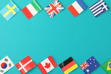 Photo of Small paper flags of different countries on light blue background, flat lay. Space for text