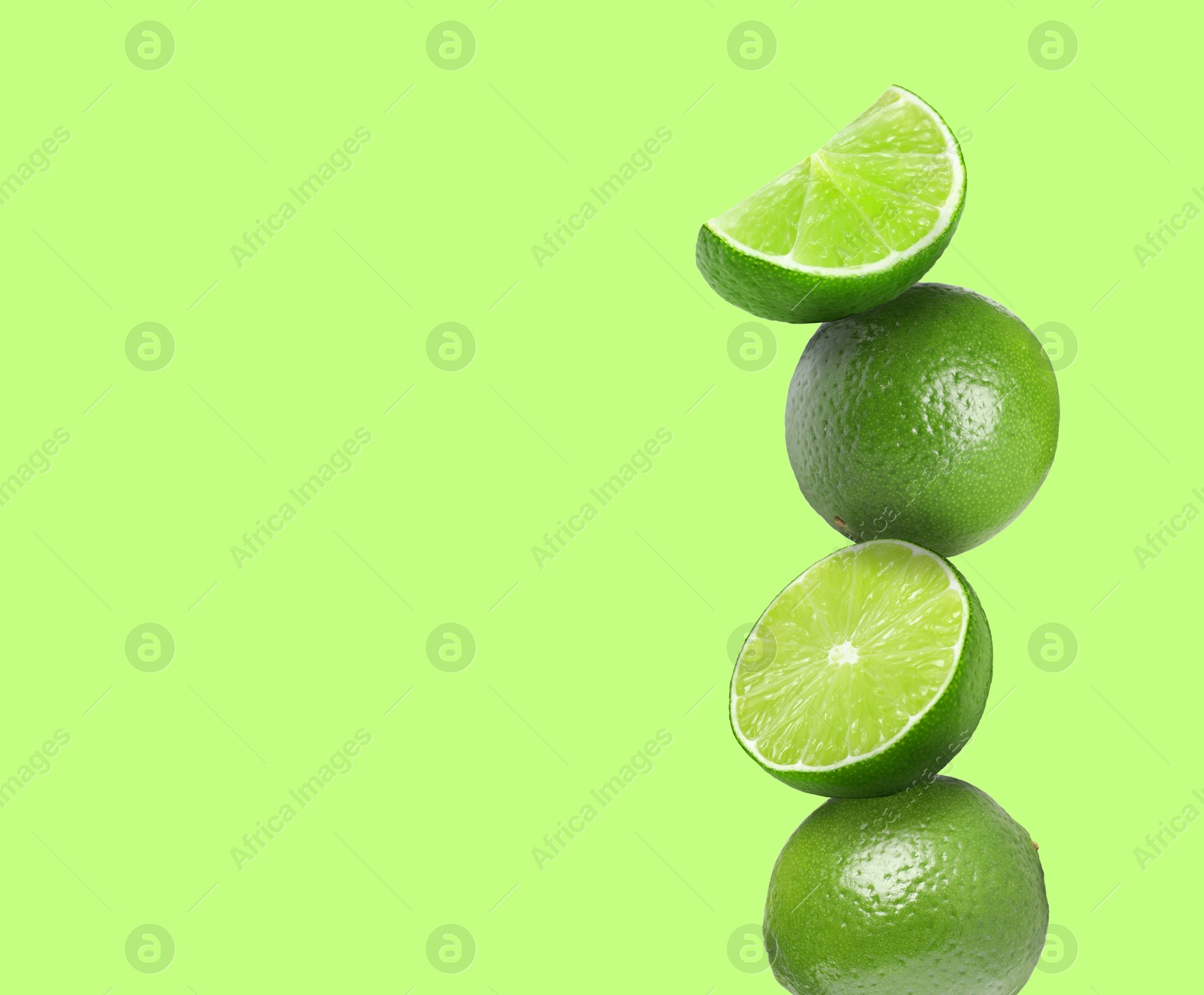 Image of Stacked fresh limes on light green background, space for text