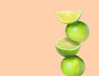 Image of Stacked fresh limes on pink background, space for text